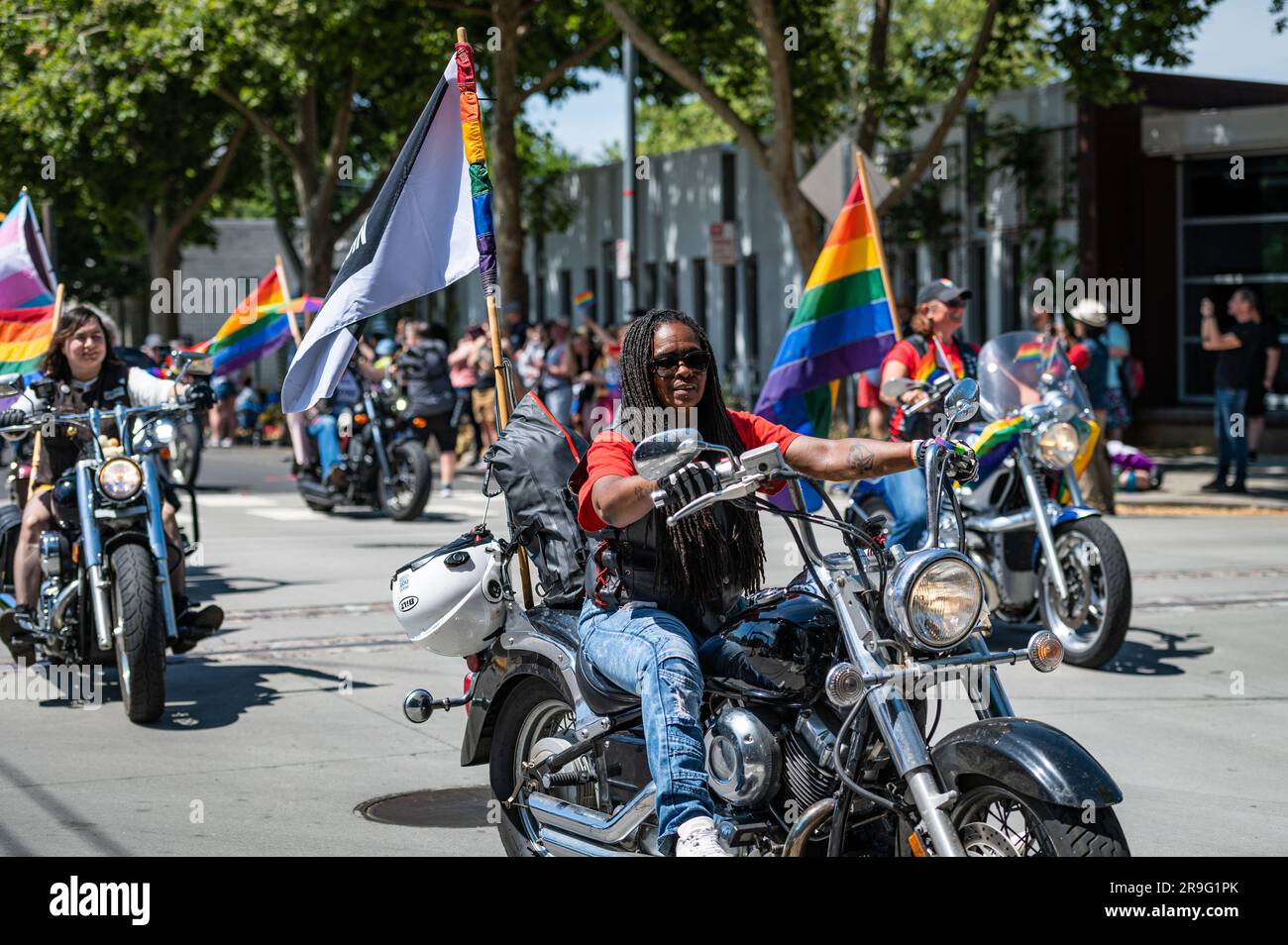 Foto di una donna afro-americana su una moto all'inizio e della tradizionale "Dykes on Bikes" parte dell'annuale Sacramento Pride Parade. Foto Stock