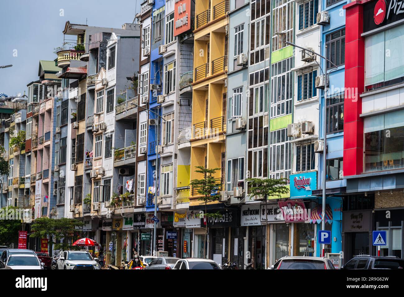Ha Long, Vietnam -- 19 marzo 2023. Una foto scattata con un teleobiettivo di aziende ed edifici multicolore in una strada trafficata di ha Long, Vietna Foto Stock