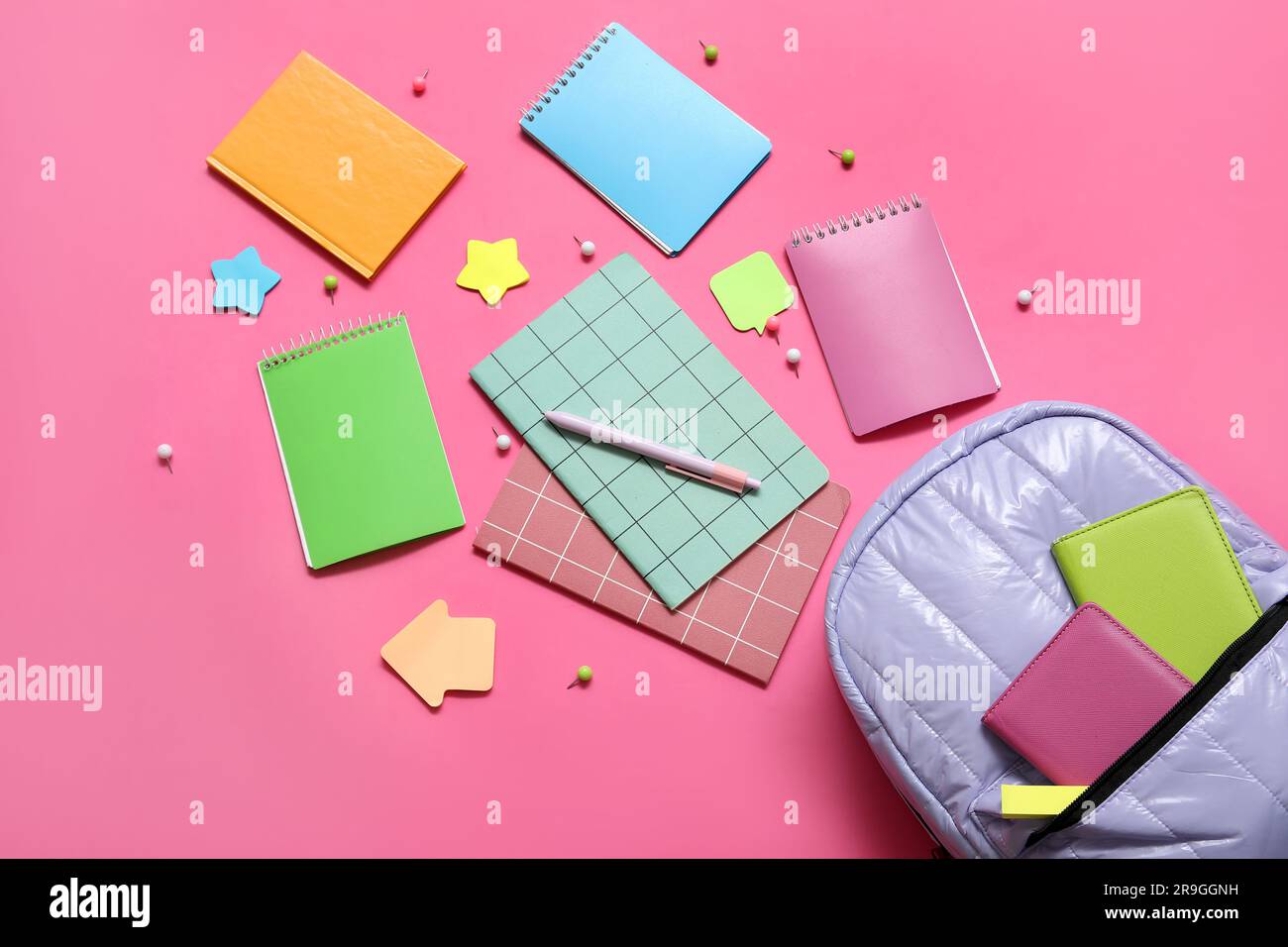 Zaino scuola lilla con quaderni, adesivi e spille su sfondo rosa Foto stock  - Alamy