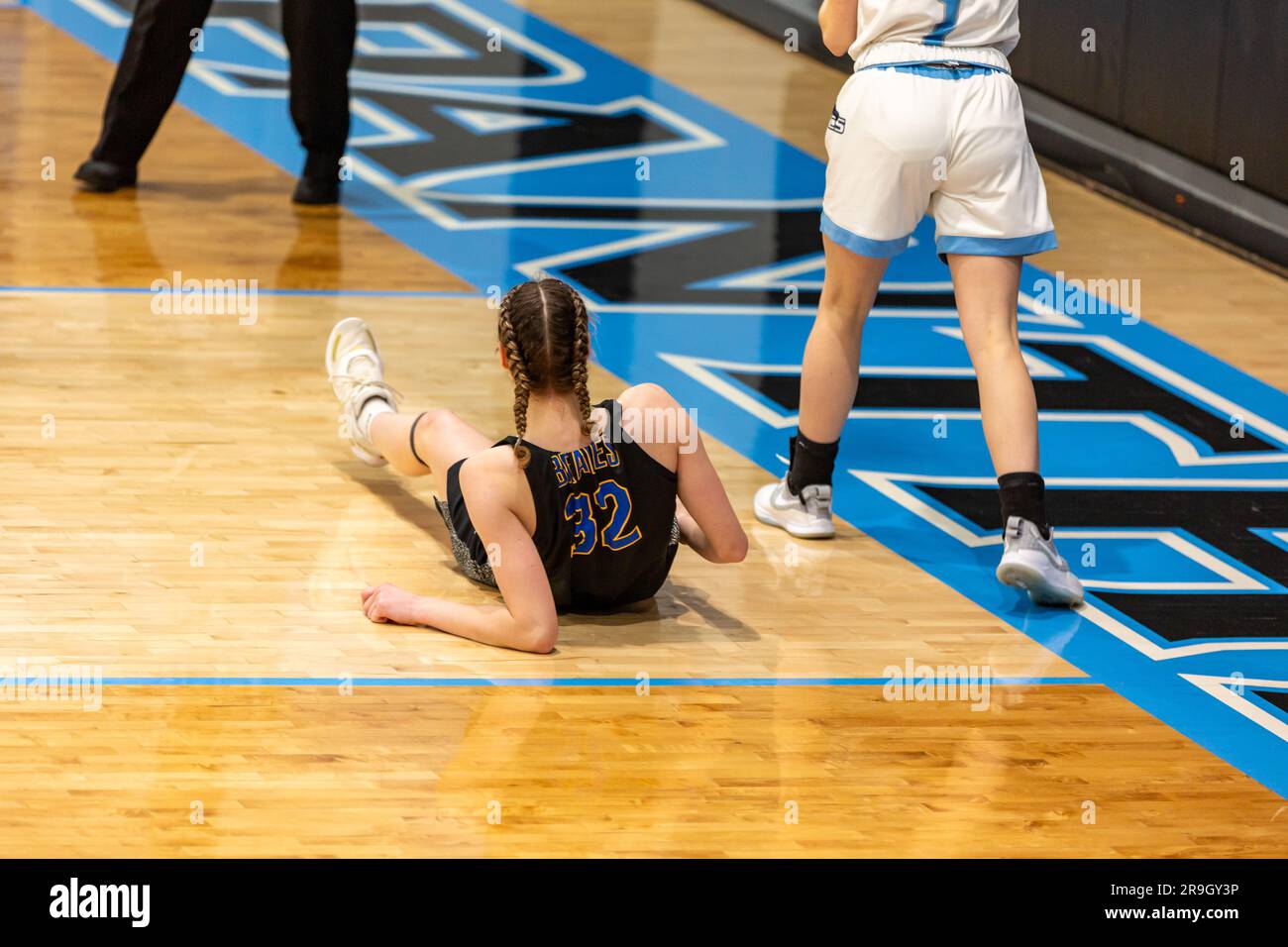 Un giocatore caduto è sul pavimento dopo una partita durante una partita di pallacanestro delle scuole superiori ad Auburn, Indiana, USA. Foto Stock
