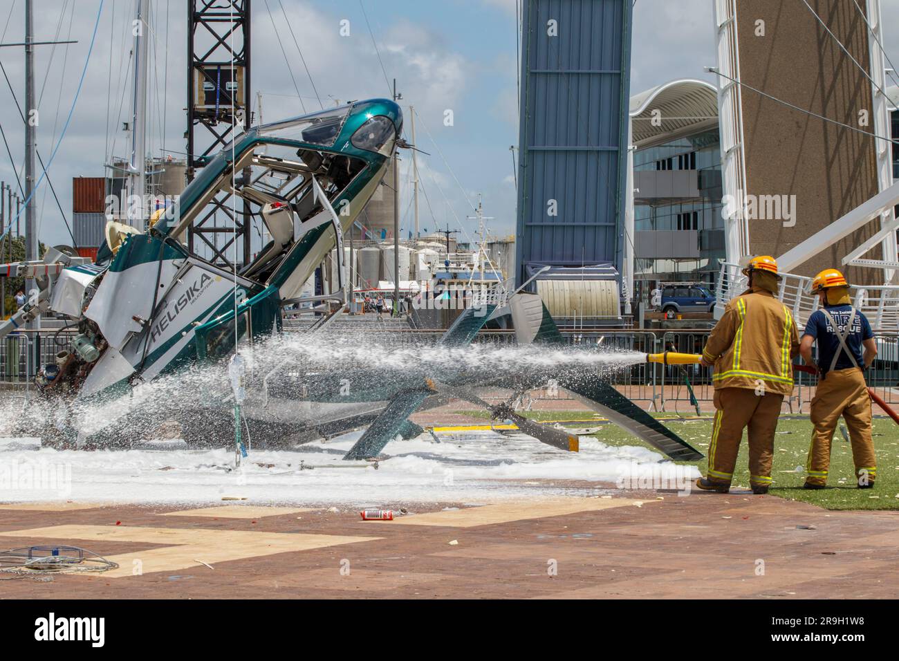 Fireman spruzza schiuma sulla scena di un incidente in elicottero, Viaduct Harbour, Auckland, nuova Zelanda Foto Stock