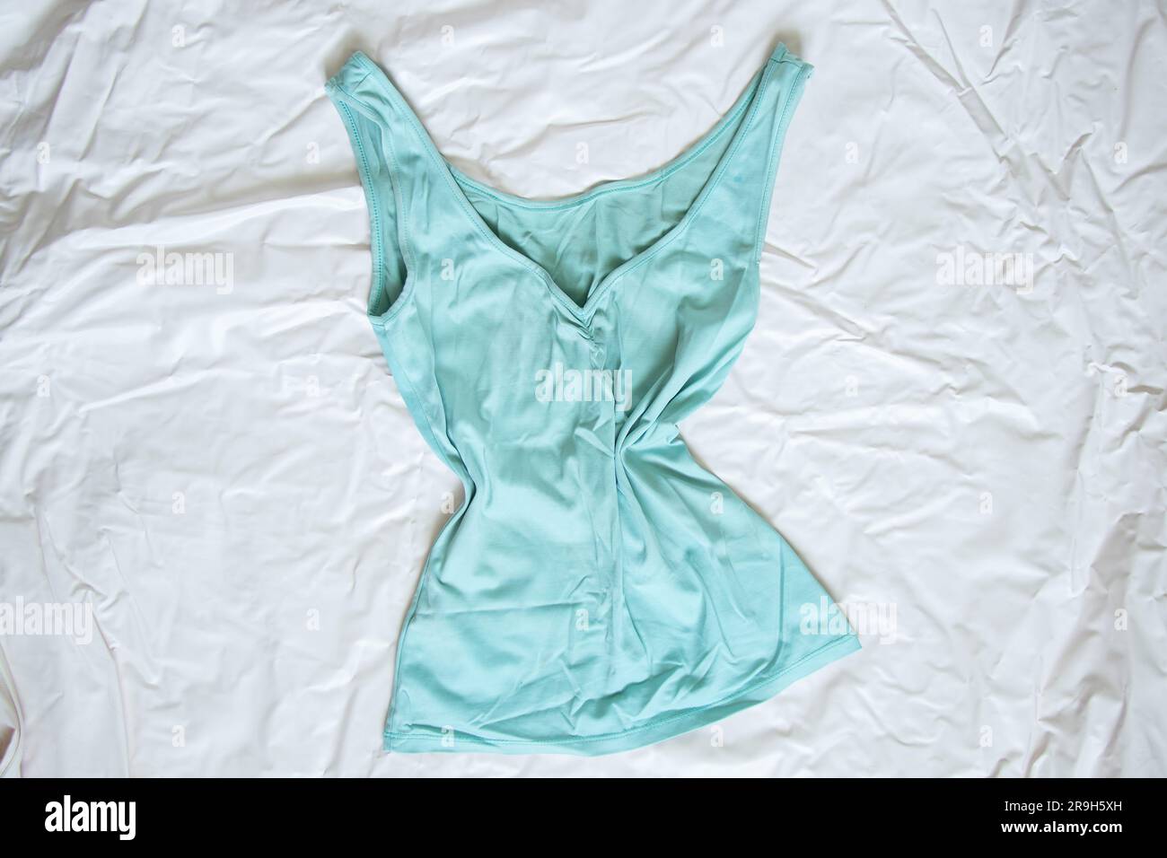 elegante t-shirt verde alla moda su sfondo bianco sgualcito, abbigliamento femminile Foto Stock