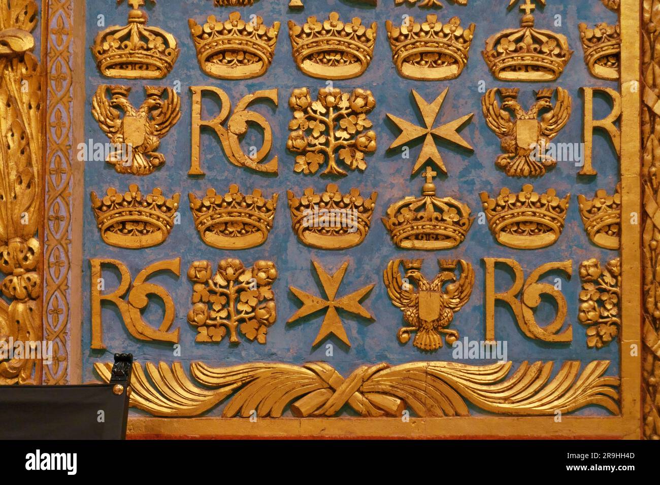 Dettagli decorativi dorati con croce maltese, monogramma 'RC' e altri simboli sulla parete all'interno di St Co-cattedrale di Giovanni a la Valletta, Malta Foto Stock
