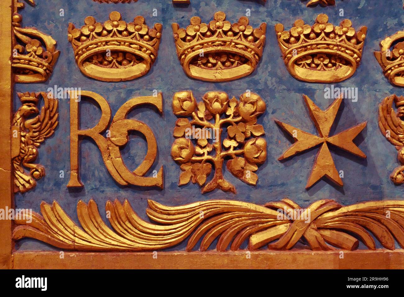 Dettagli decorativi dorati con croce maltese, monogramma 'RC' e altri simboli sulla parete all'interno di St Co-cattedrale di Giovanni a la Valletta, Malta Foto Stock