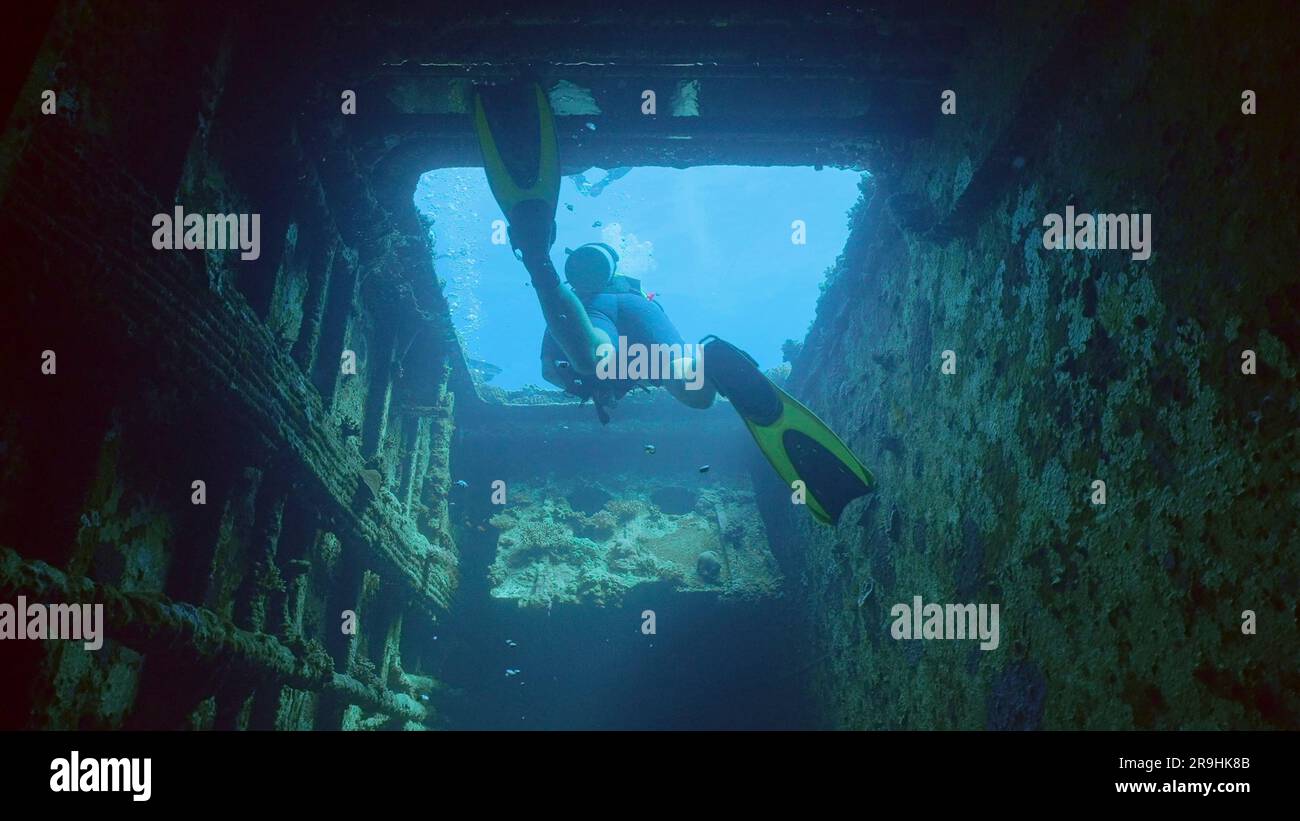 Il subacqueo nuota per uscire all'interno delle strette stive del naufragio del traghetto Salem Express, Mar Rosso, Safaga, Egitto Foto Stock