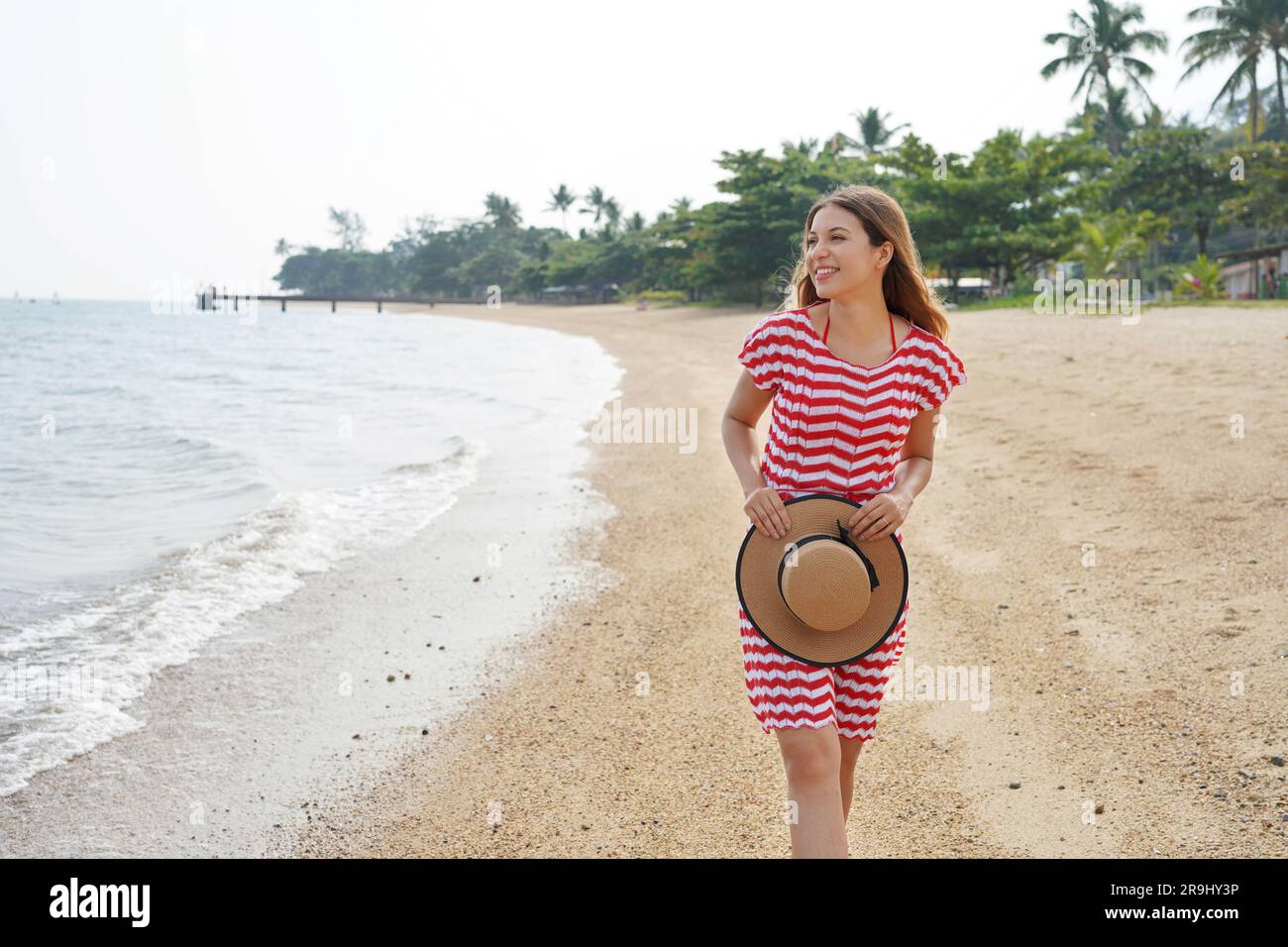 Ragazza viaggiatrice su una spiaggia tropicale vuota. Giovane donna che cammina rilassata sulla spiaggia di sabbia in Brasile. Concetto di fuga da viaggio. Foto Stock