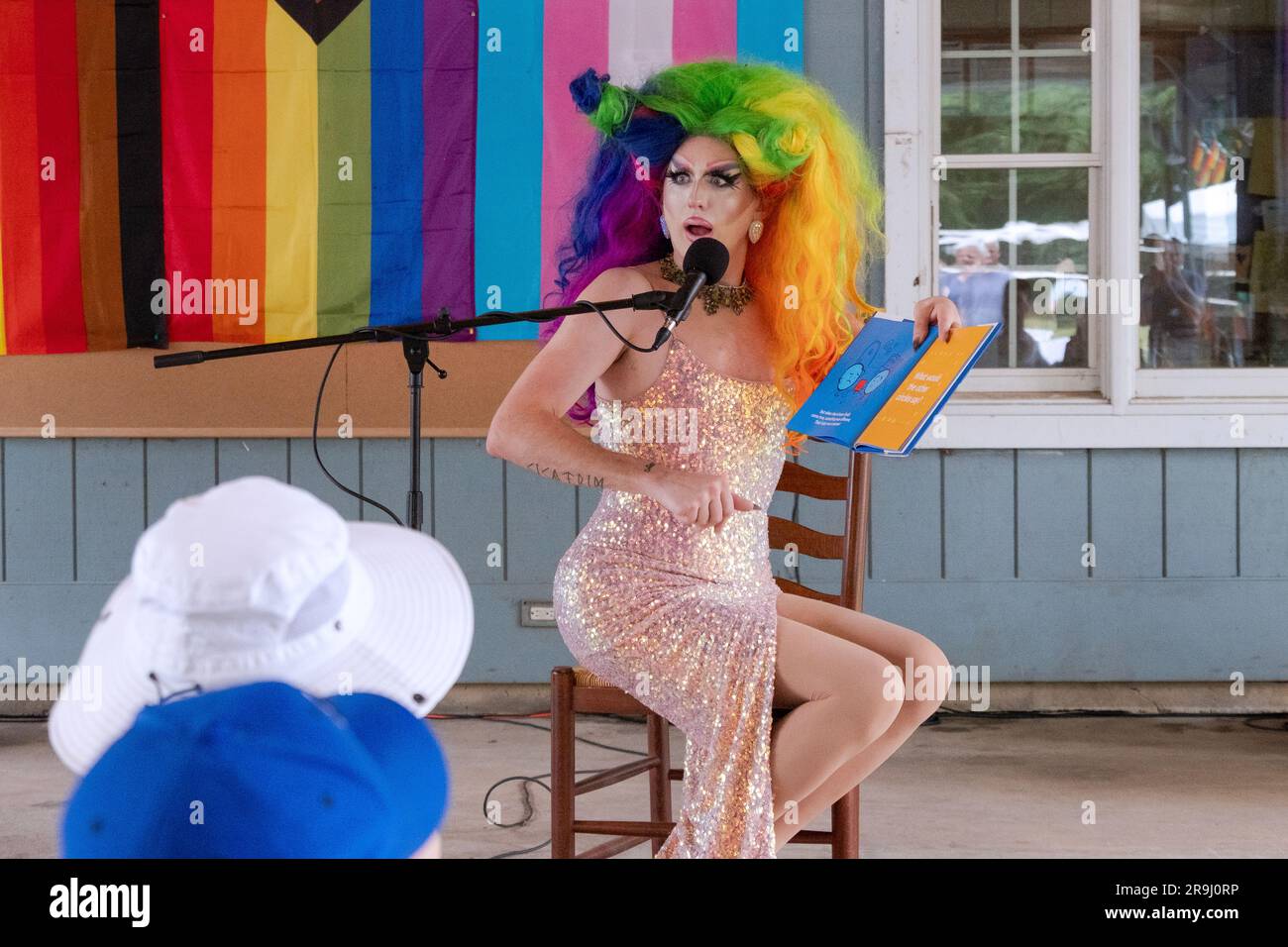 Un drag performer legge un libro ai bambini chiamato Fitting in, sull'inclusività. A Lewisboro, Westchester ad un evento Pride. Giugno 2023. Foto Stock