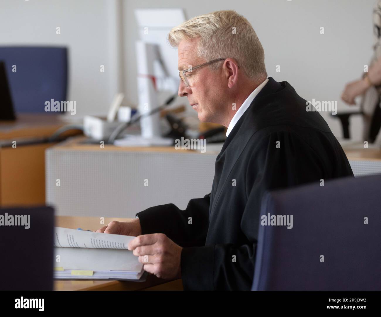 27 giugno 2023, Renania settentrionale-Vestfalia, Hamm: Richard Uhle, avvocato, siede nella sala udienza del Tribunale regionale superiore di Hamm. La Corte regionale superiore di Hamm si sta occupando di un post sui social media durante la pandemia di Corona. Nel post del presunto negatore Corona su Facebook, il portavoce della polizia di Amburgo al vertice del G20 poteva essere visto in uniforme delle SS su un fotomontaggio. Foto: Dieter Menne/dpa Foto Stock