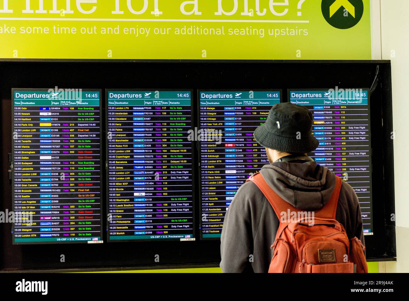 I passeggeri guardano i tabelloni elettronici delle partenze dei voli all'aeroporto di Dublino, in Irlanda. Foto Stock