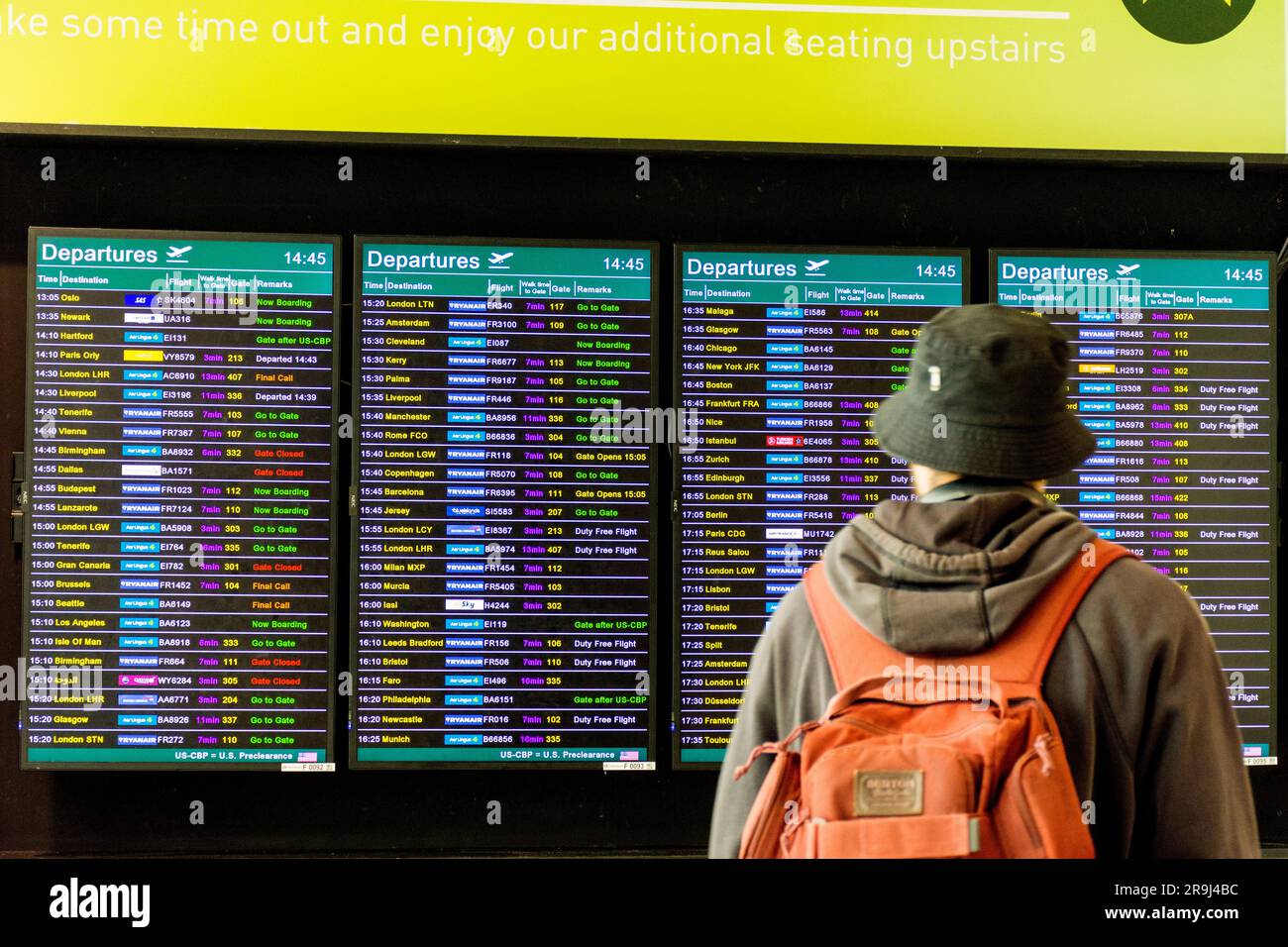 I passeggeri guardano i tabelloni elettronici delle partenze dei voli all'aeroporto di Dublino, in Irlanda. Foto Stock