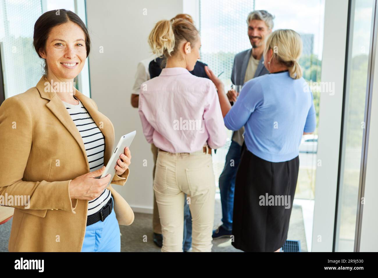 Ritratto di una donna d'affari sorridente in piedi con un tablet PC Foto Stock
