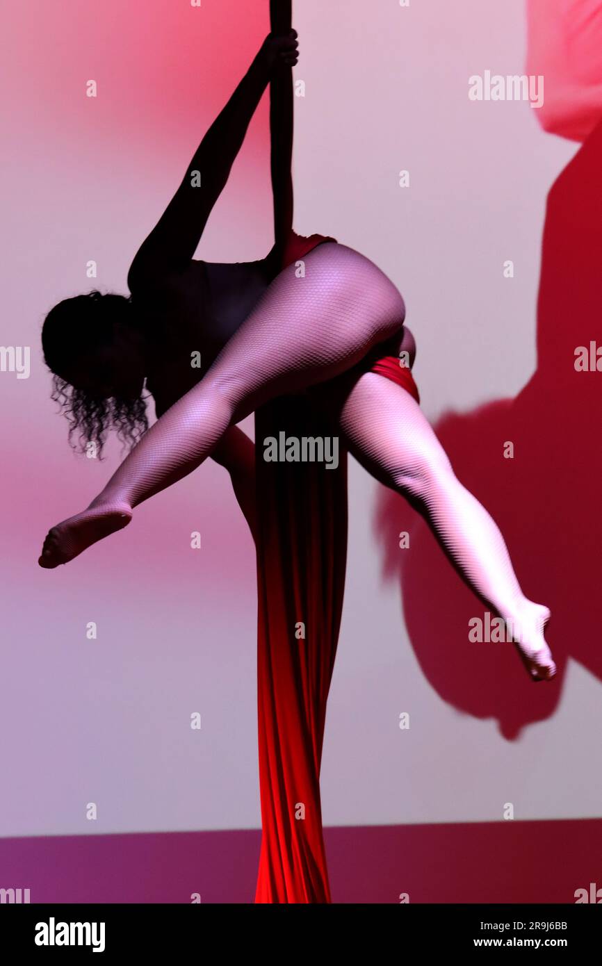 Ballerina acrobatica aerea su tessuti rossi Foto Stock