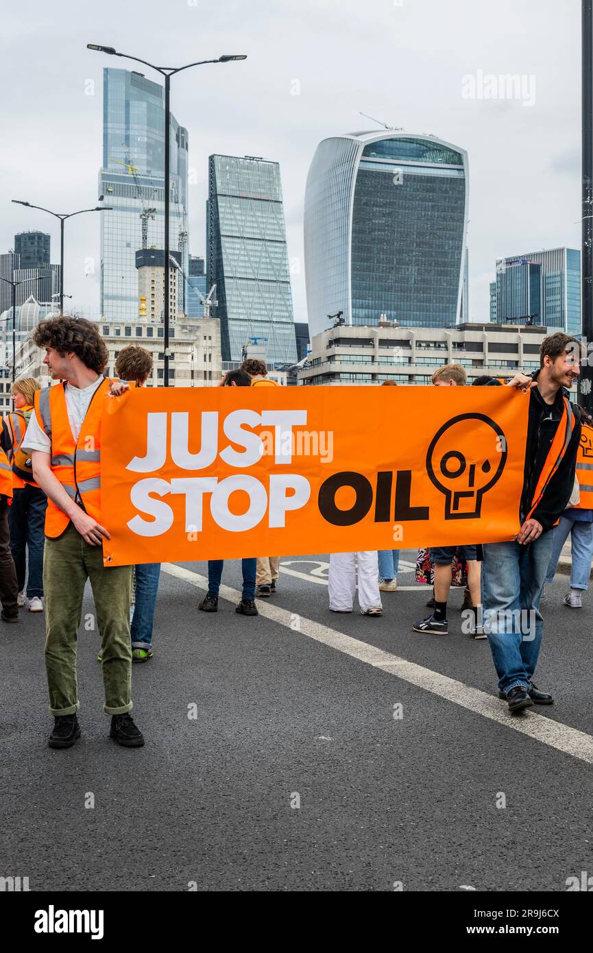 Londra, Regno Unito. 27 giugno 2023. La polizia inizia immediatamente ad avvertire la protesta che stanno bloccando la strada e causando e offendere ai sensi della sezione 12 del Public Order Act - basta fermare la protesta petrolifera al London Bridge. L'obiettivo generale del gruppo è quello di convincere il governo a fermare tutti i nuovi giacimenti petroliferi nell'ambito degli sforzi volti ad evitare la crisi climatica. Crediti: Guy Bell/Alamy Live News Foto Stock