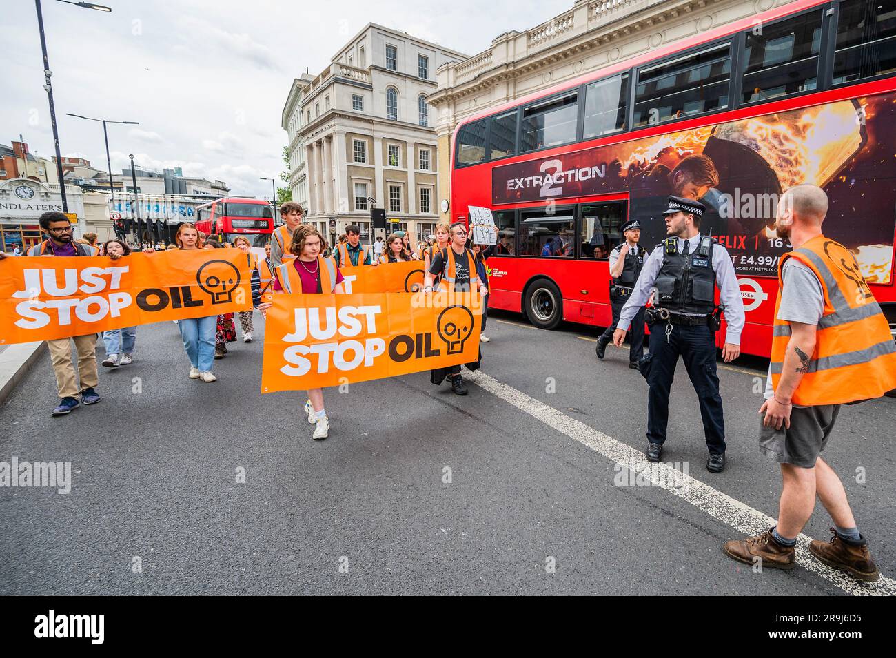 Londra, Regno Unito. 27 giugno 2023. Estrazione 2 (un autobus che viene lasciato passare ha un annuncio appropriato dalla sua parte) - la polizia continua ad avvertire la protesta che stanno bloccando la strada e causando e offendere ai sensi della sezione 12 del Public Order Act - basta fermare la protesta petrolifera al London Bridge. L'obiettivo generale del gruppo è quello di convincere il governo a fermare tutti i nuovi giacimenti petroliferi nell'ambito degli sforzi volti ad evitare la crisi climatica. Crediti: Guy Bell/Alamy Live News Foto Stock