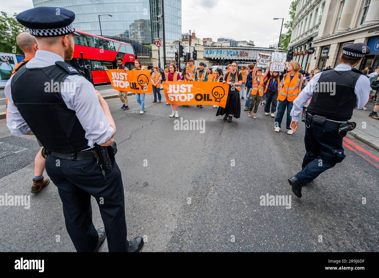 Londra, Regno Unito. 27 giugno 2023. La polizia inizia immediatamente ad avvertire la protesta che stanno bloccando la strada e causando e offendere ai sensi della sezione 12 del Public Order Act - basta fermare la protesta petrolifera al London Bridge. L'obiettivo generale del gruppo è quello di convincere il governo a fermare tutti i nuovi giacimenti petroliferi nell'ambito degli sforzi volti ad evitare la crisi climatica. Crediti: Guy Bell/Alamy Live News Foto Stock