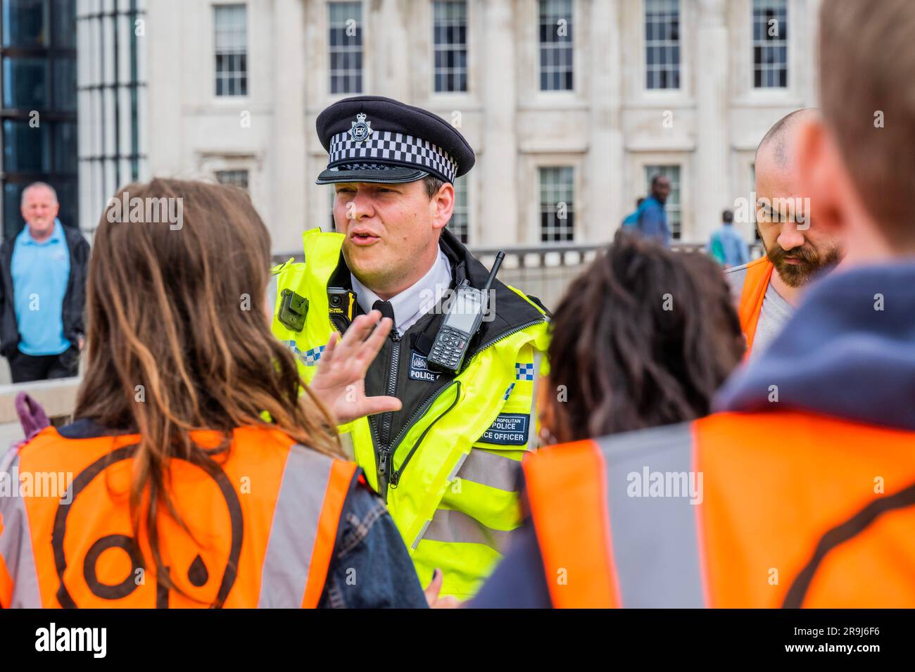 Londra, Regno Unito. 27 giugno 2023. L'ufficiale anziano presente dà un ultimo avvertimento e i manifestanti lasciano la strada dopo averla ammassata a metà del ponte - la polizia aveva già avvertito che stavano causando e offendere ai sensi della sezione 12 del Public Order Act - basta fermare la protesta petrolifera al London Bridge. L'obiettivo generale del gruppo è quello di convincere il governo a fermare tutti i nuovi giacimenti petroliferi nell'ambito degli sforzi volti ad evitare la crisi climatica. Crediti: Guy Bell/Alamy Live News Foto Stock