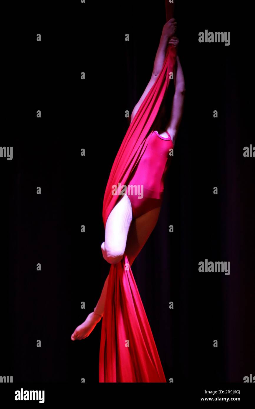 Ballerina acrobatica aerea su tessuti rossi Foto Stock