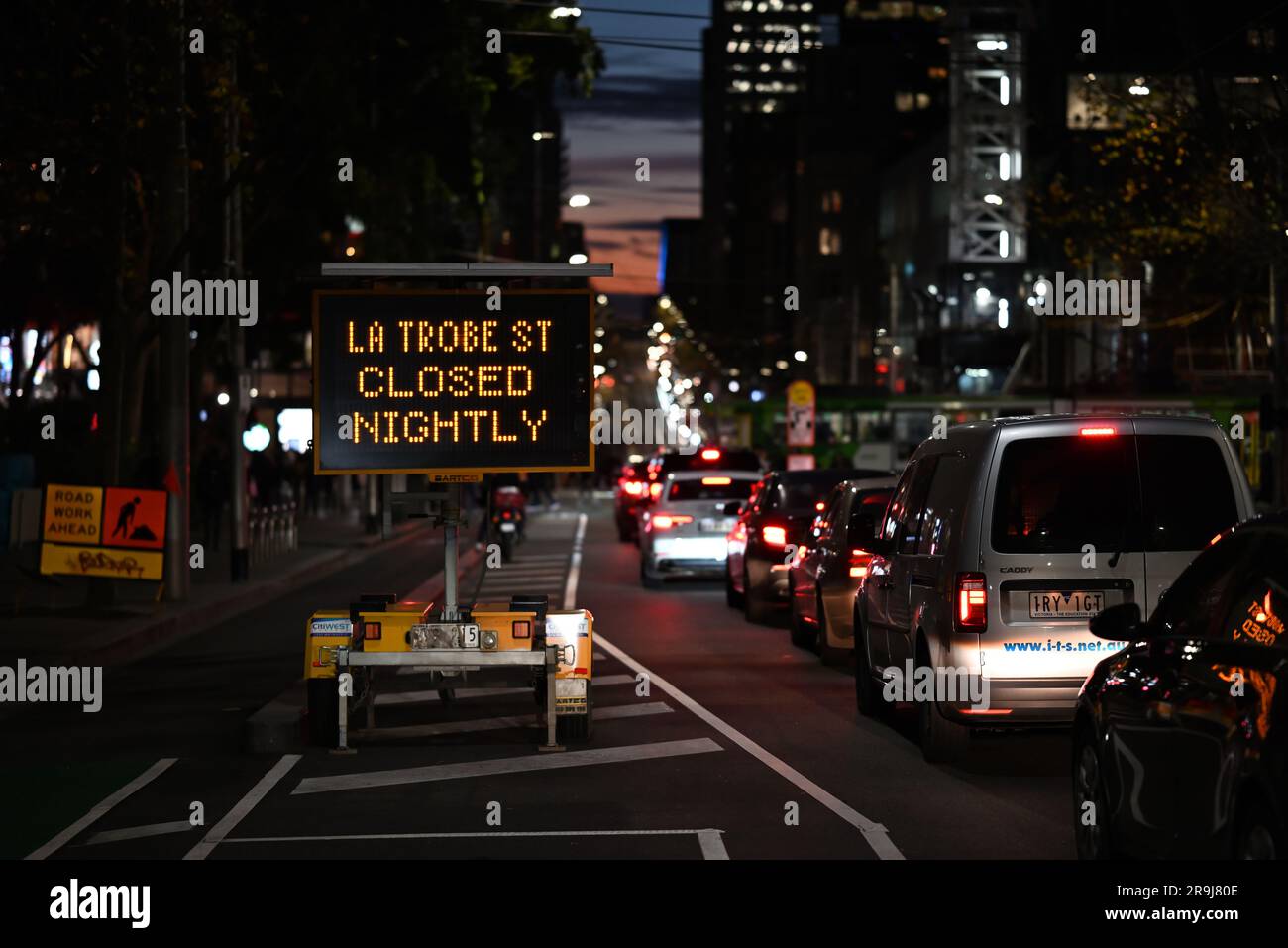 Il traffico in direzione ovest si fermava su la Trobe Street vicino a un cartello segnaletico di chiusure notturne delle strade, nelle prime ore della sera d'inverno Foto Stock