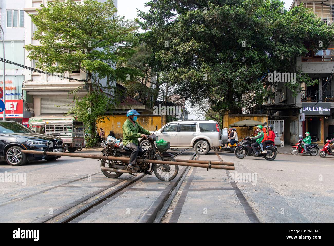 Hanoi, Vietnam - aprile 2023; vista dall'angolo basso della strada trafficata con i tubi che attraversano i binari della famosa linea ferroviaria attraverso ce Foto Stock