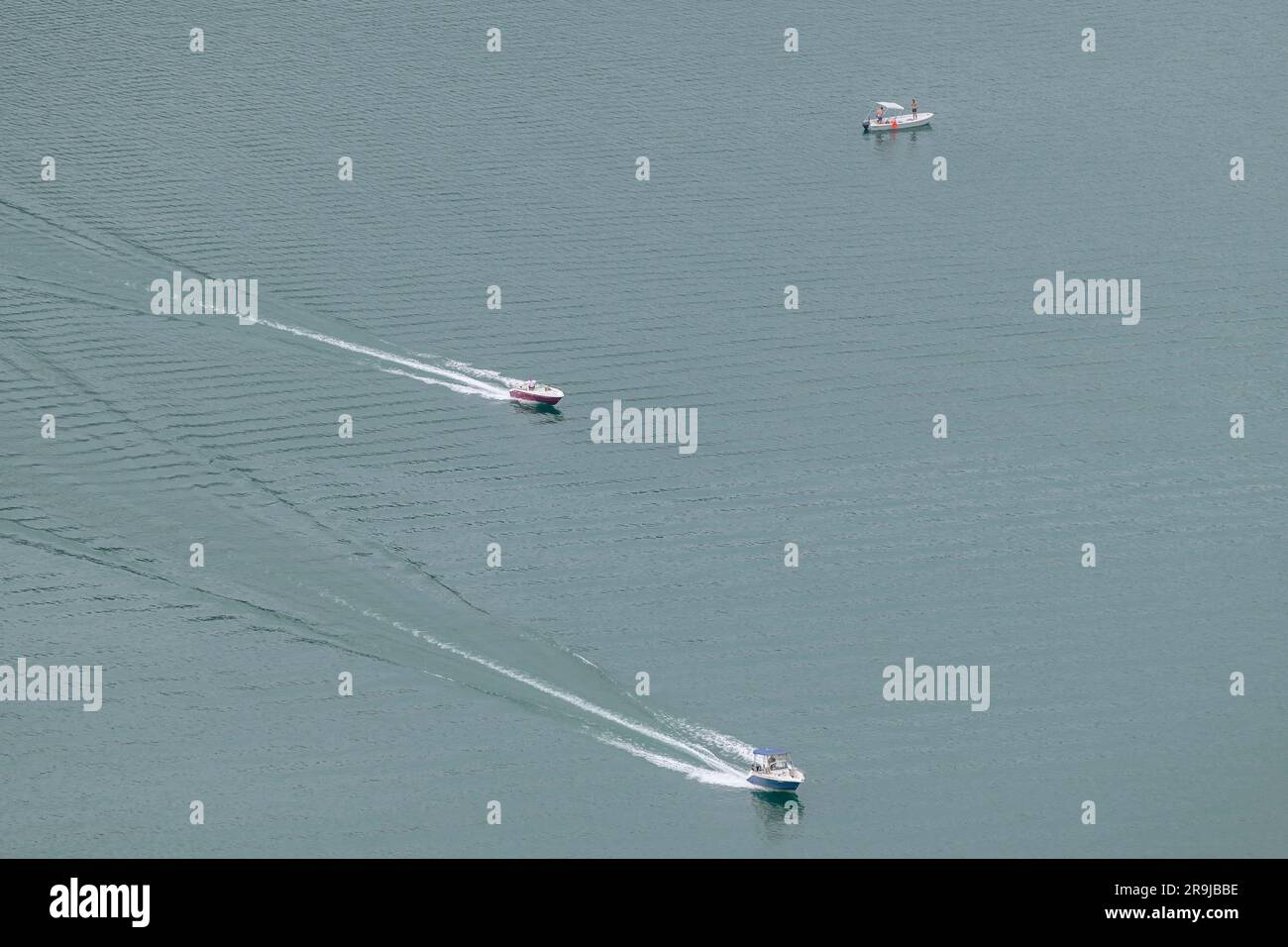 Tre motoscafi, due dei quali in movimento, visti dall'alto, lago di Lugano, confine Svizzera-Italia Foto Stock