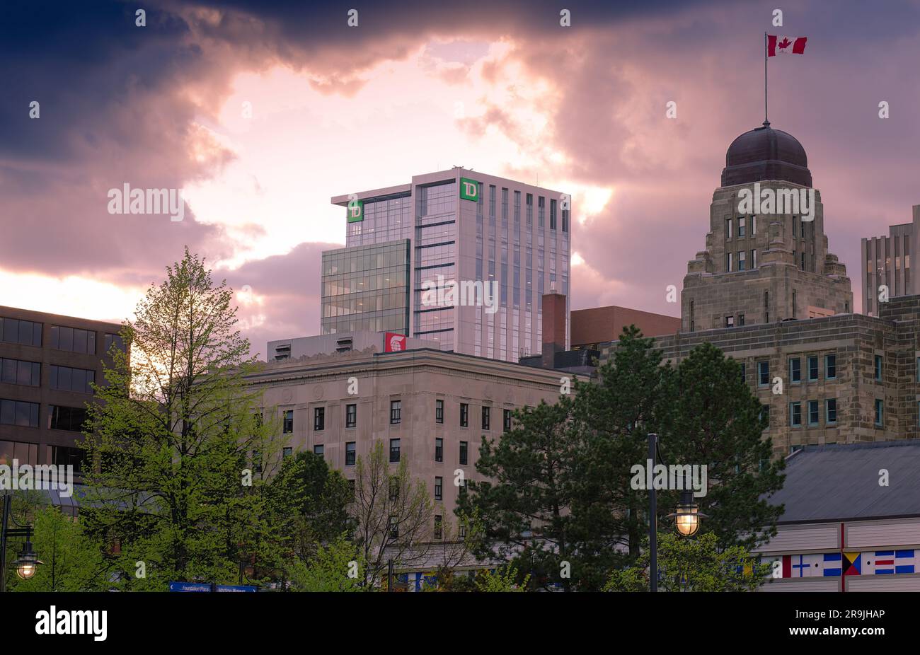 Halifax, NS, Canada - LUGLIO 2021 - bandiera del Canada in cima all'edificio pubblico Historic Dominion, alle istituzioni finanziarie TD Bank e Scotia Bank Foto Stock