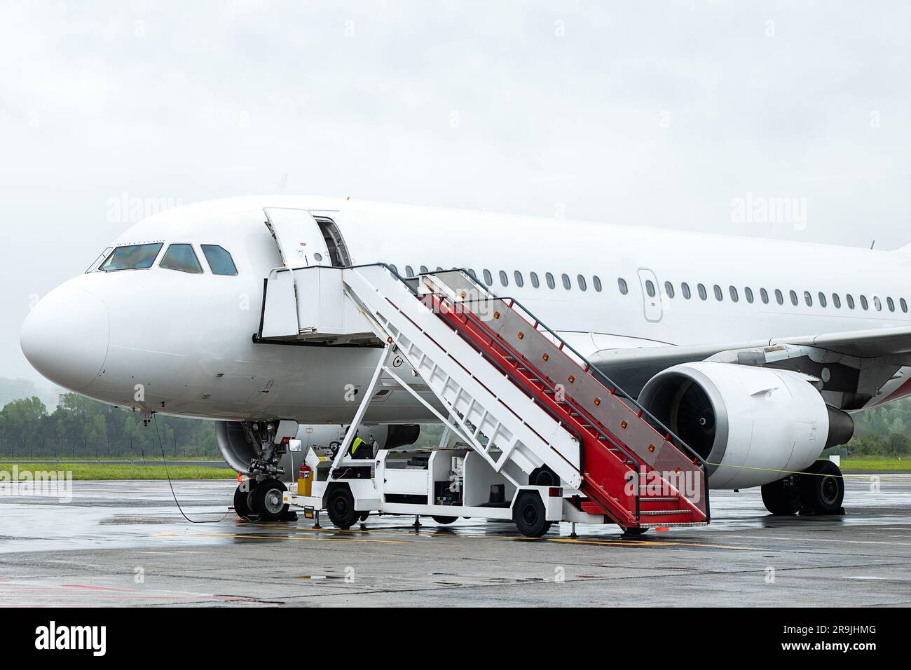Velivolo moderno di grandi dimensioni con scala preparata per il volo in aeroporto nelle giornate nuvolose Foto Stock