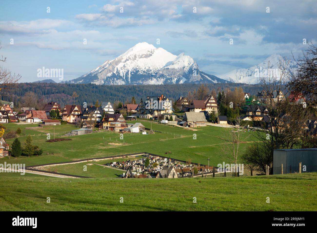 Paesaggio degli alti Tatra con ville di lusso nel villaggio di Murzasichle che forniscono alloggio e un cimitero Foto Stock