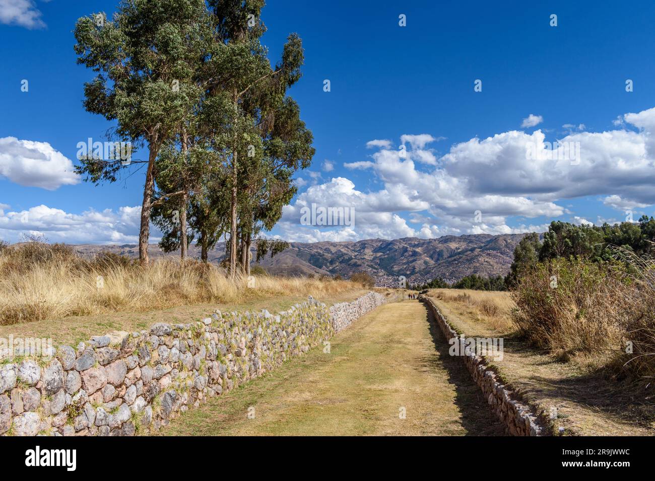 Il paesaggio della provincia di Urubamba, la vista sulle montagne e un sentiero affondato con pareti in pietra, un esempio dello stile architettonico inca. Foto Stock