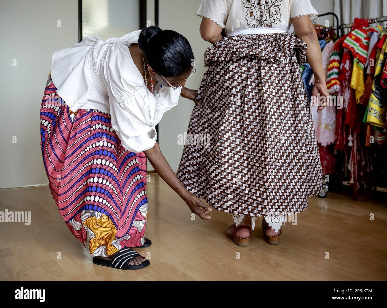 AMSTERDAM - Flos durante l'allestimento alla nonna Rinia Overman (l) del koto, un capo tradizionale di donne creole in Suriname, in vista di Keti Koti. Il 1° luglio saranno 160 anni fa che i Paesi Bassi hanno deciso di abolire la schiavitù e 150 anni fa che gli ultimi schiavi sono diventati liberi. ANP ROBIN VAN LONKHUIJSEN paesi bassi Out - belgio Out Foto Stock