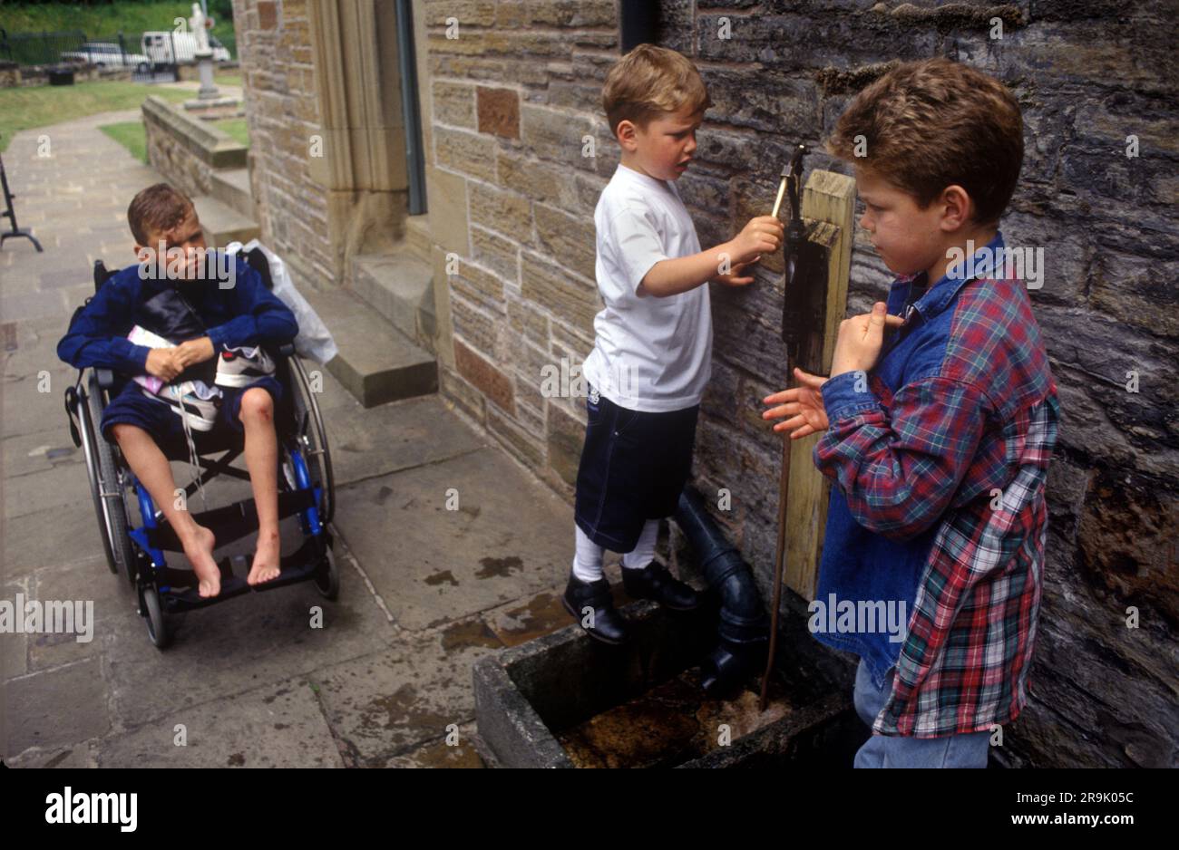 Santuario di Saint Winefrides, Holywell. La festa del santo celtico Winifred. Bambini zingari, usare acqua di sorgente sacra per guarire da soli. Holywell ,Flintshire Wales, UK 1990S.. HOMER SYKES Foto Stock