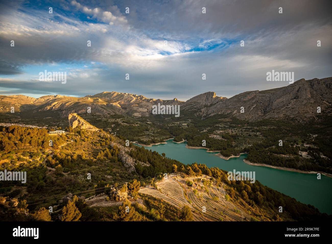 Vista panoramica del bacino idrico di Guadalest, Alicante, Spagna, con le montagne sullo sfondo e il cielo con le nuvole. Foto Stock