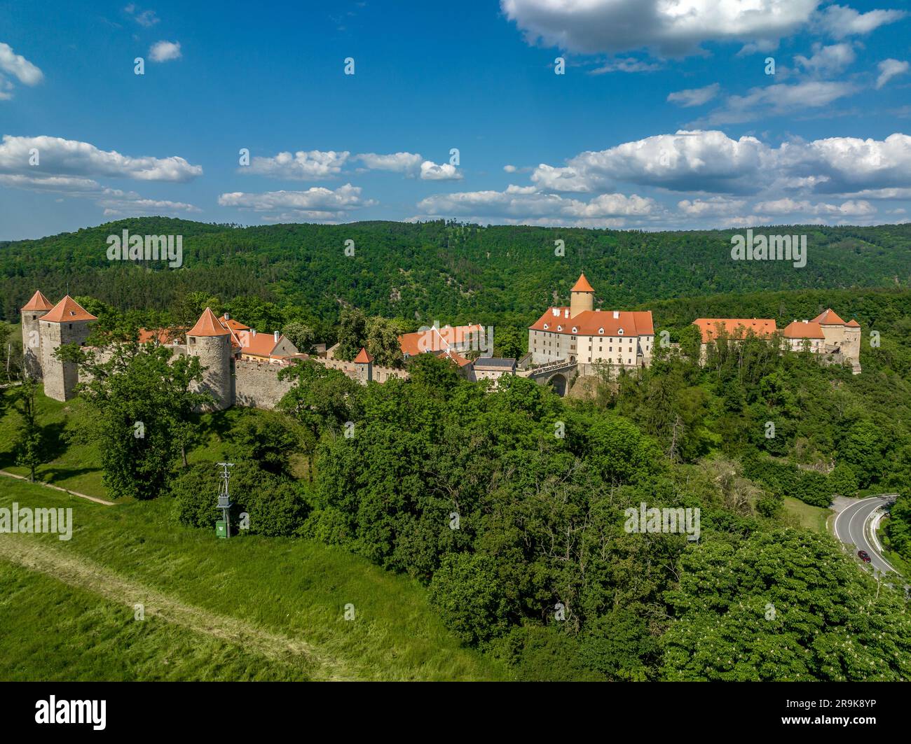 Vista aerea del castello di Veveri in Moravia con grandi cortili, porte multiple, torri quadrate e rotonde con cielo blu nuvoloso Foto Stock