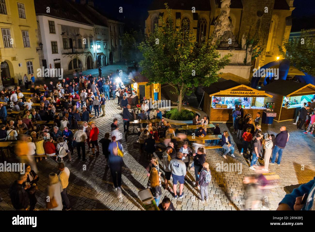 La gente mangia e parla davanti al Muzeumnegyed (quartiere dei musei) il giorno della notte dei musei, Sopron, Ungheria Foto Stock