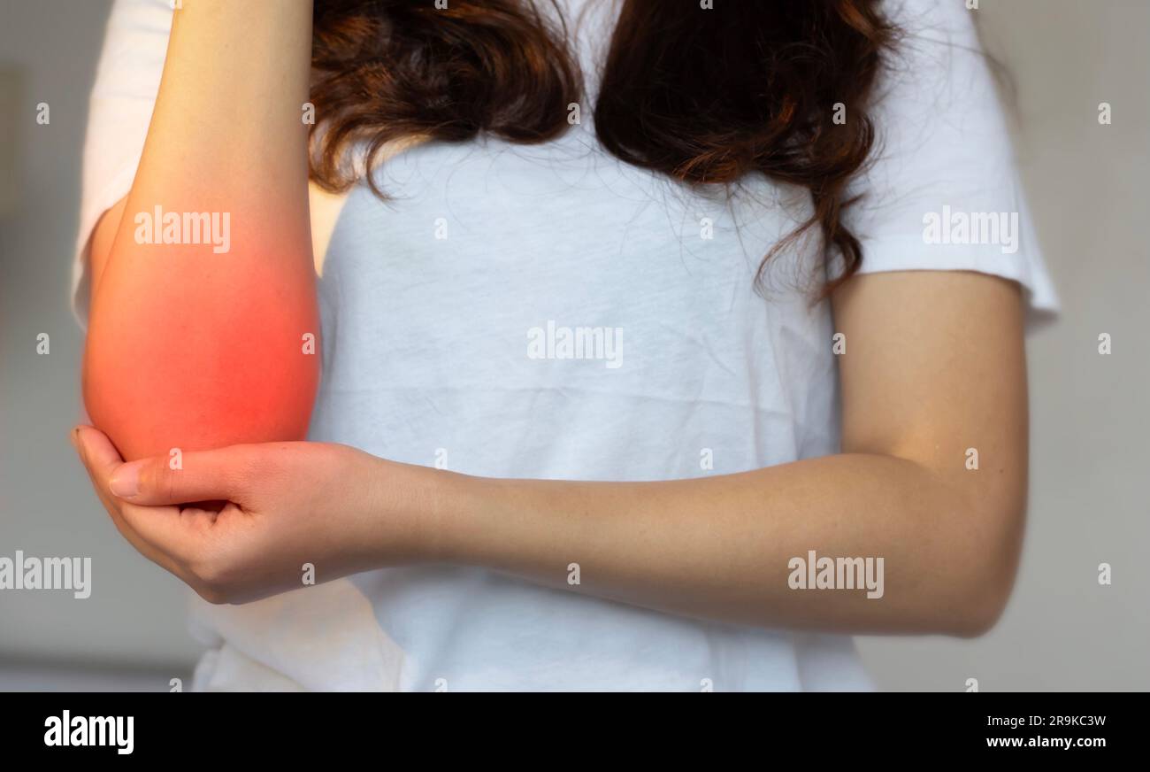 Dolore all'articolazione del gomito della giovane donna asiatica. Concetto di dolore al gomito, lesioni, reumatismi o osteoartrite. Foto Stock