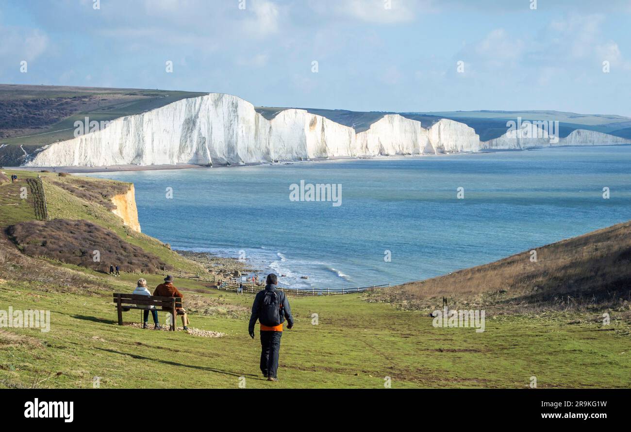 Eastbourne, Regno Unito, 21 gennaio 2023. Vista posteriore di un escursionista di sesso maschile che cammina verso la scogliera Seven Sisters in Inghilterra in una giornata di sole. Foto Stock