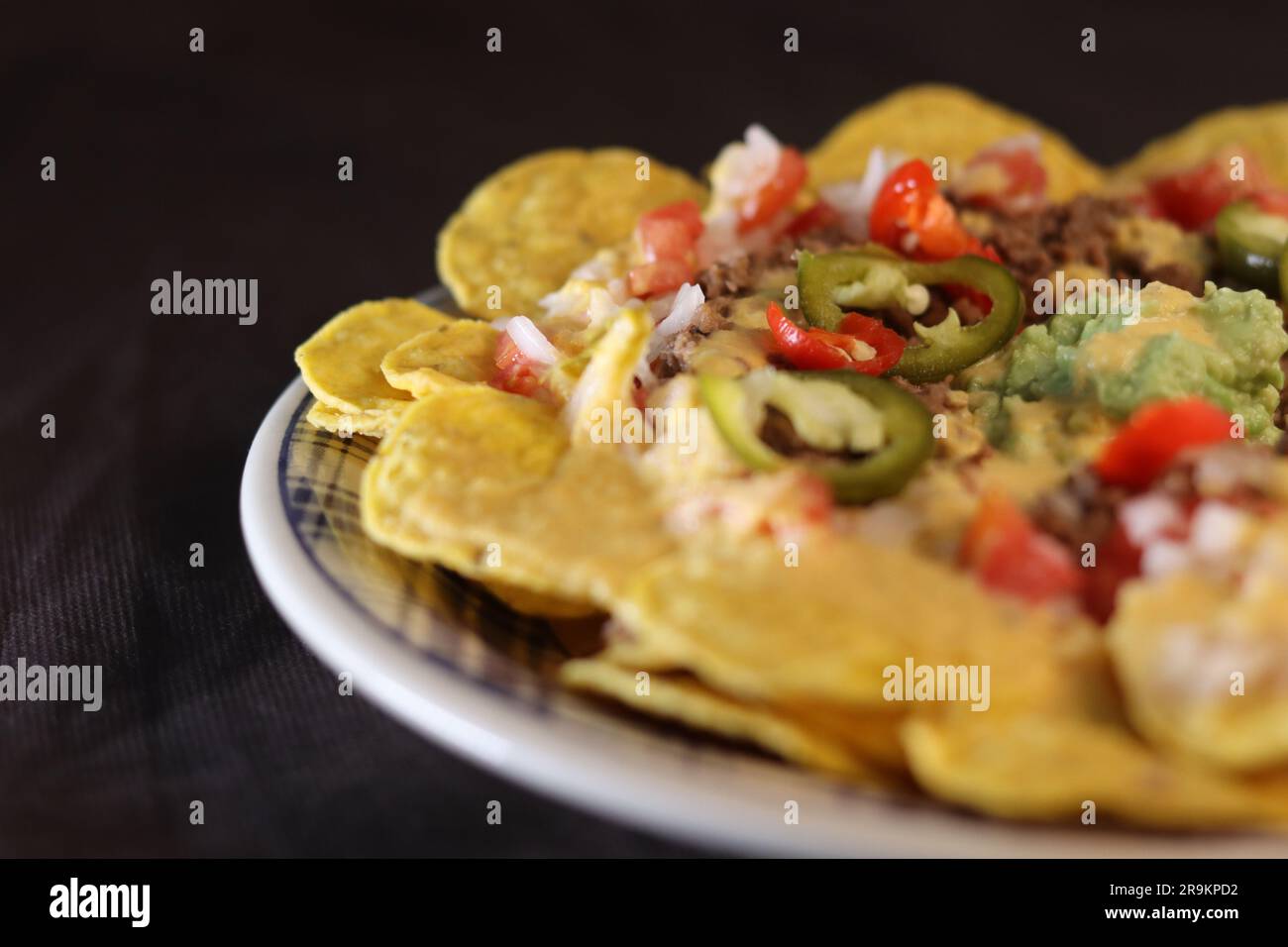 Emplatado de nachos con carne, ensalada, y pimiento Foto Stock