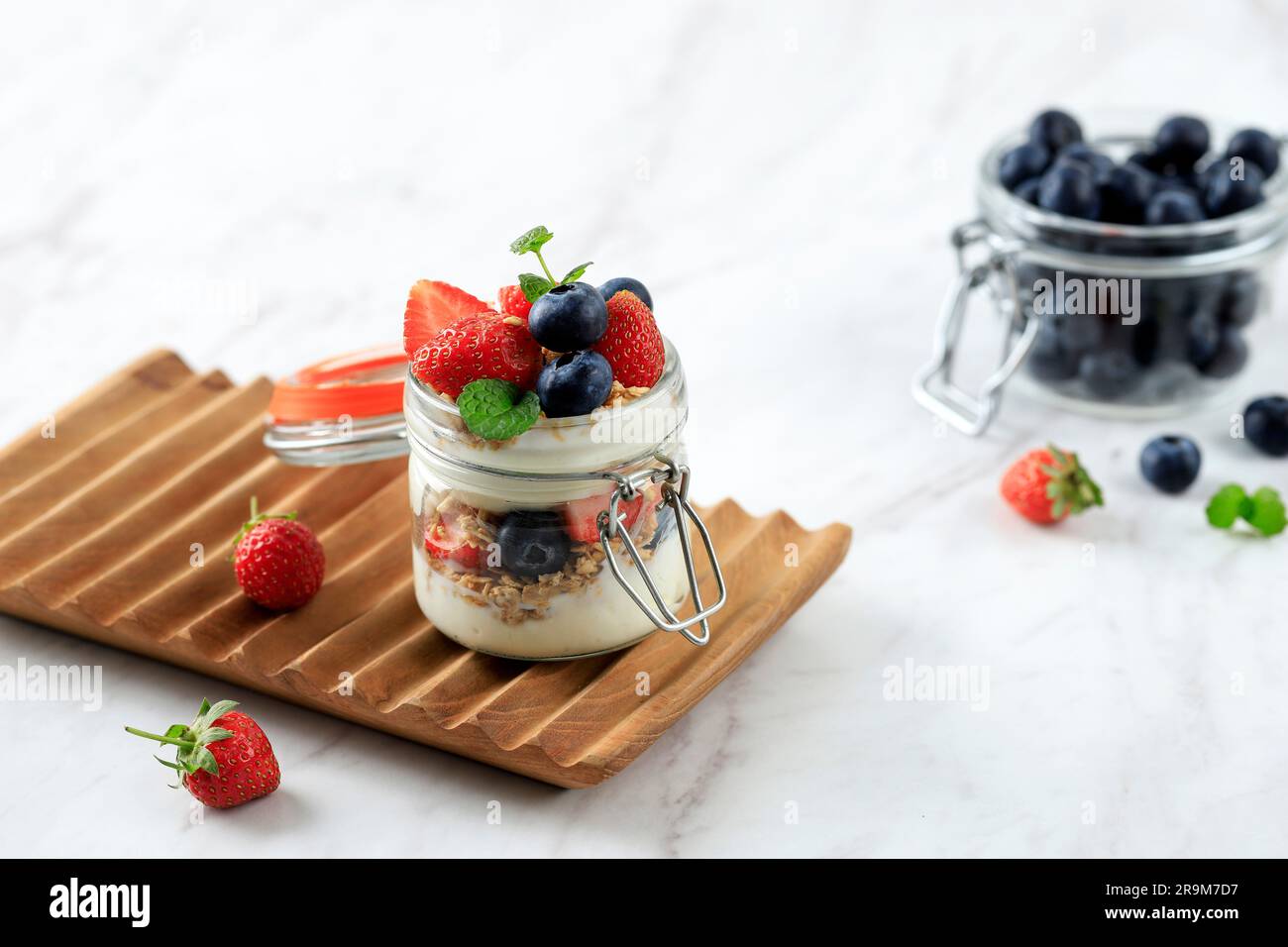 Parfait di muesli, yogurt semplice con fragole fresche e mirtilli. Servire in mini-vasetto Foto Stock