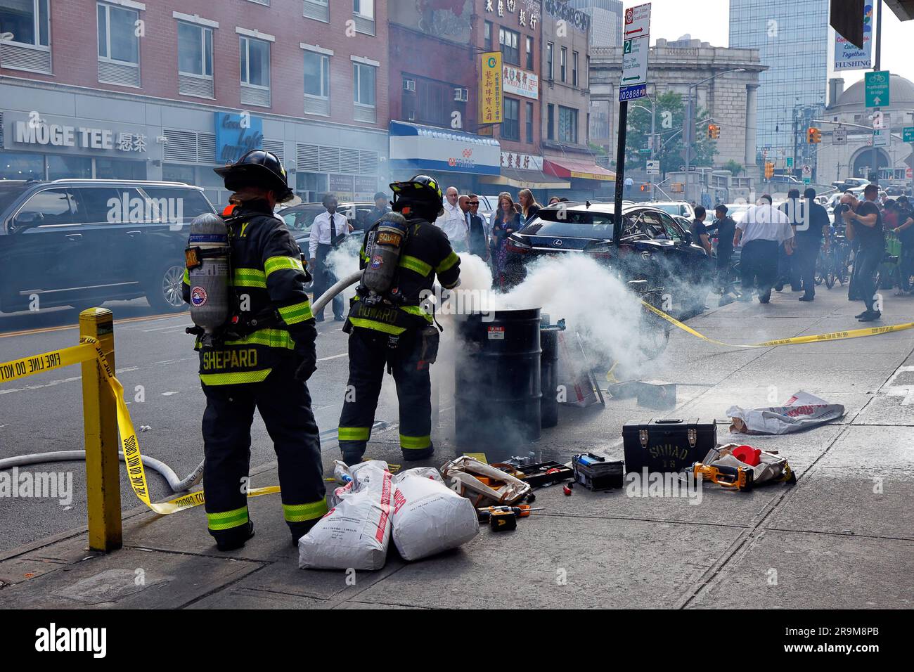 New York, USA, 27 giugno 2023, i vigili del fuoco dell'FDNY ispezionano un centro di riparazione per biciclette elettriche a Manhattan Chinatown alla ricerca di batterie agli ioni di litio difettose e non sicure. Nella foto: Il Commissario dei vigili del fuoco di New York Laura Kavanagh e altri funzionari della città guardano i vigili del fuoco che estinguono un incendio causato da una batteria elettrica agli ioni di litio che è stata accidentalmente forata durante lo smaltimento causando un cortocircuito. Recenti morti per l'incendio del 20 giugno in un negozio di biciclette elettriche su Madison St--on in cima a molti altri incendi quest'anno incolpato di batterie per biciclette elettriche in tutta la città - ha spronato la città verso una maggiore applicazione. Foto Stock