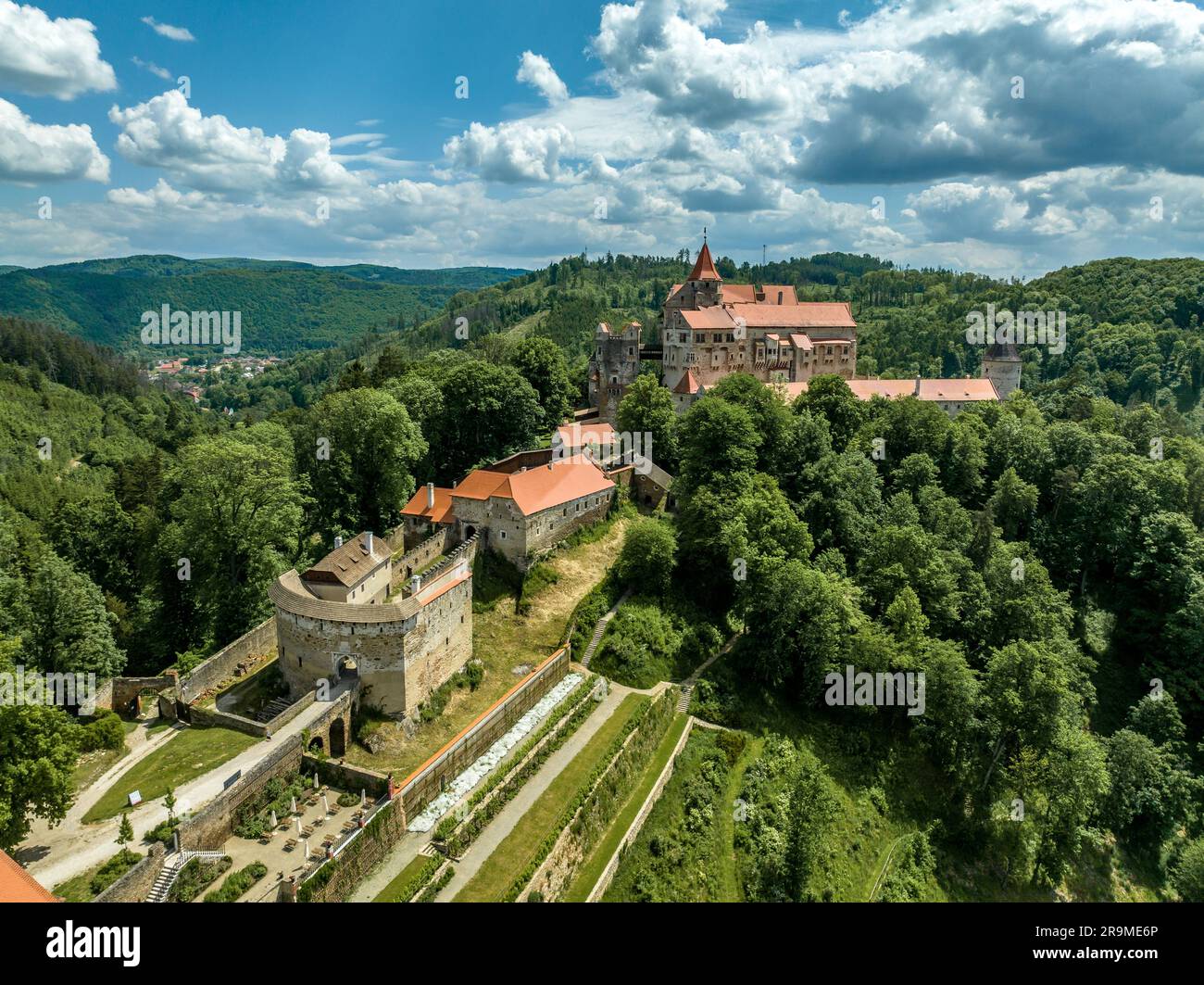 Vista aerea del castello di Pernstejn con il tetto rosso del palazzo gotico, torri rettangolari e rotonde, barbacane, piattaforma di cannoni in Moravia Foto Stock