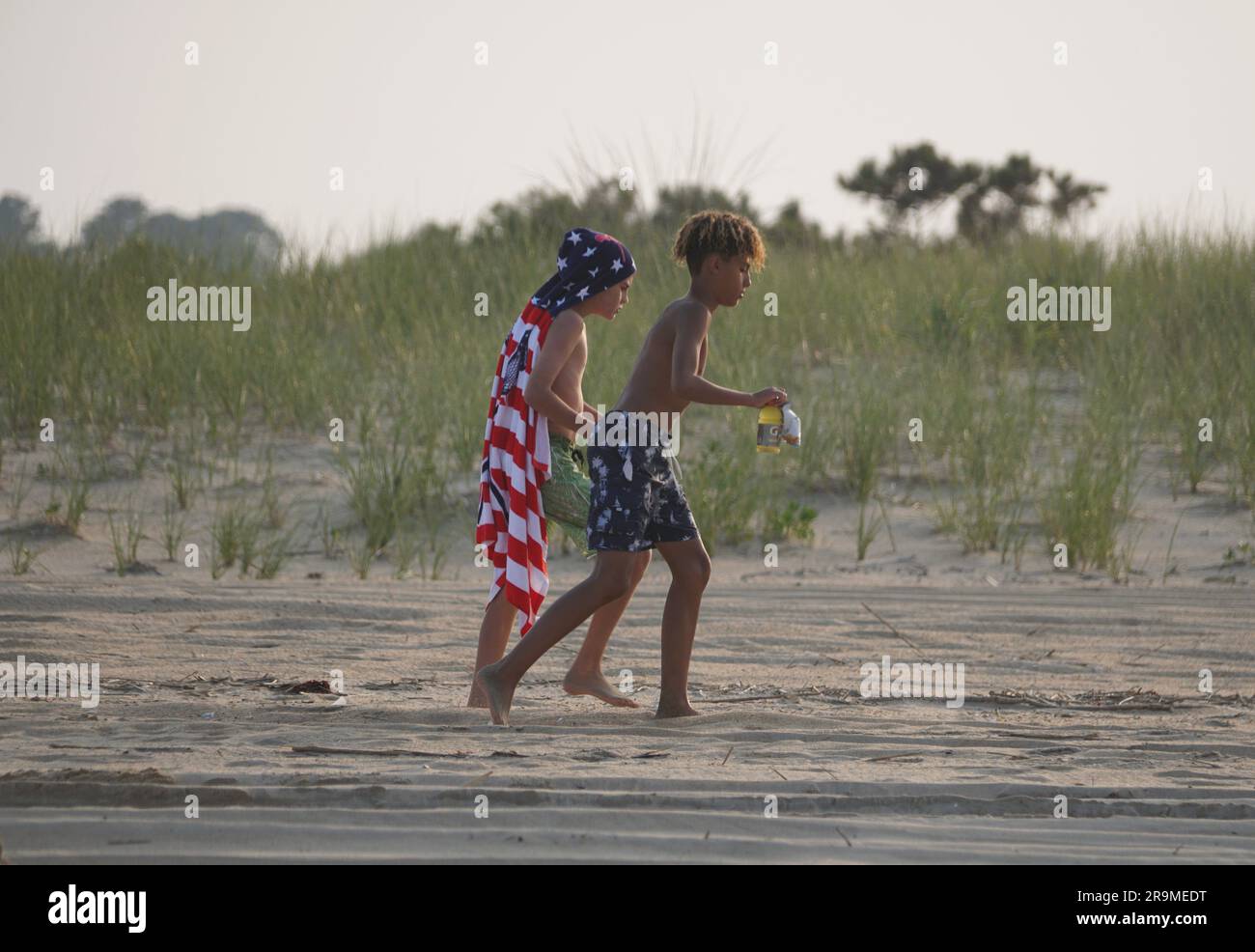 Rehoboth Beach, Delaware, U.S.A - 18 giugno 2023 - due bambini che camminano sulla sabbia vicino alle dune della spiaggia Foto Stock