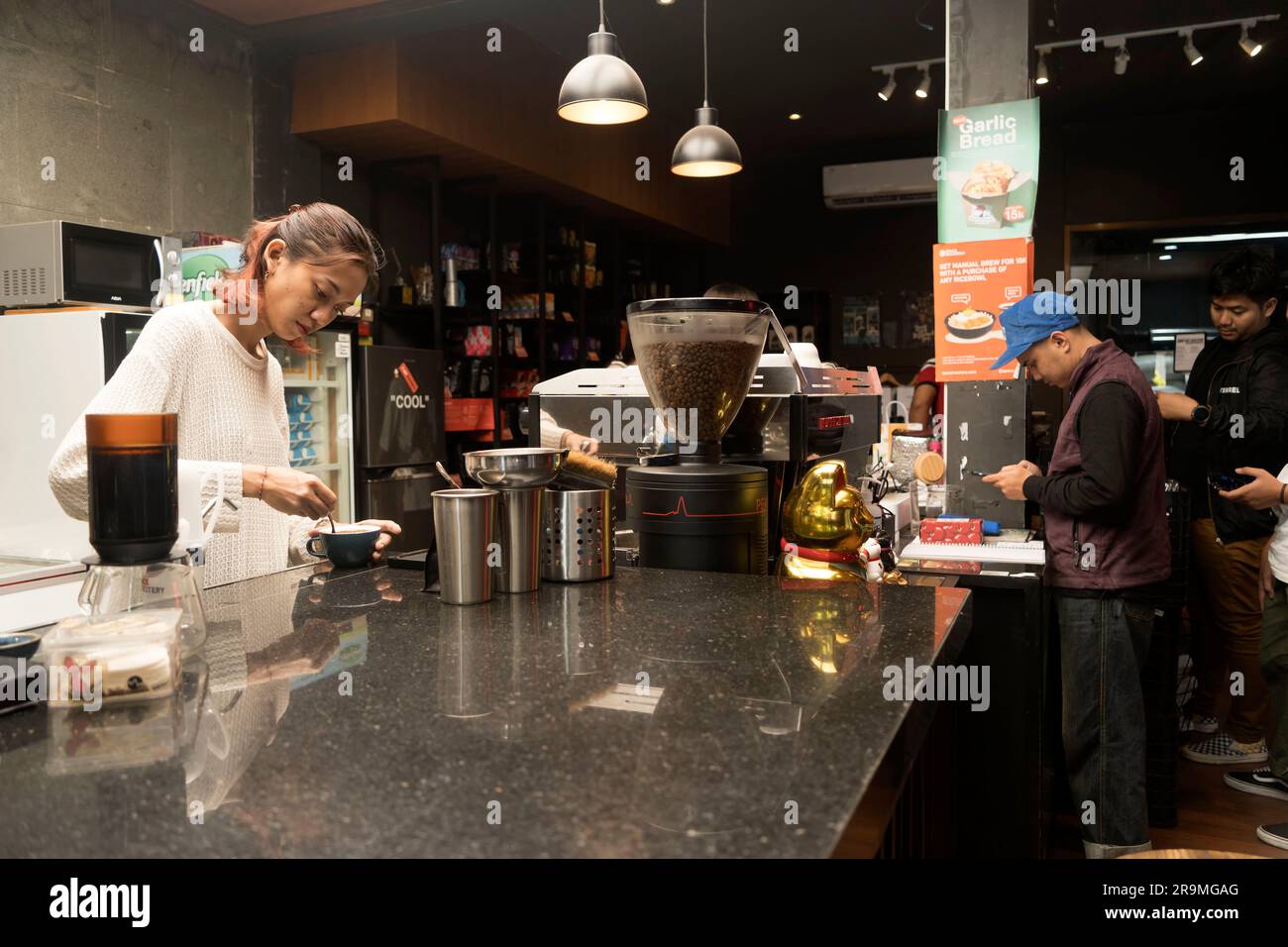 1° giugno 2023. Barista donna che prepara il caffè per il cliente presso la caffetteria di Yogykarta, Indonesia. Persone in fotografia d'azione. Foto Stock