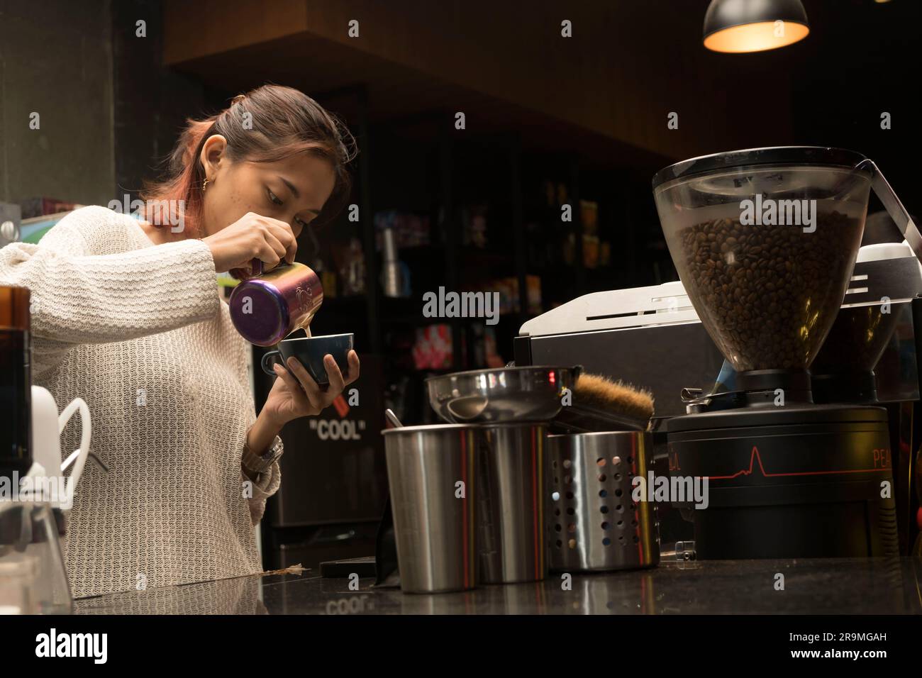 1° giugno 2023. Barista donna che prepara il caffè per il cliente presso la caffetteria di Yogykarta, Indonesia. Persone in fotografia d'azione. Foto Stock