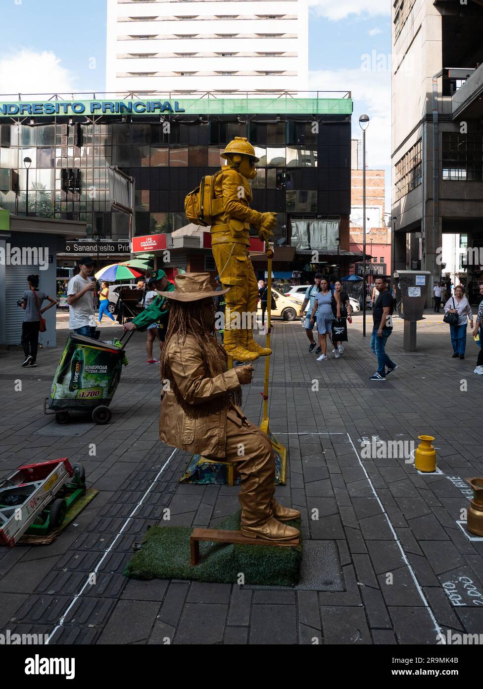 Medellin, Antioquia, Colombia - 21 novembre 2022: Esibizione di Street Artists, una donna coperta d'oro, con cappello e occhiali e un uomo in pieno Foto Stock