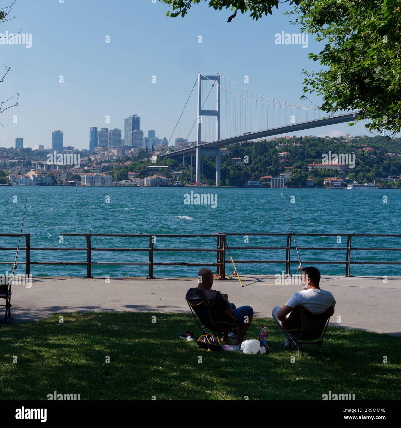Ponte dei Martiri (15 Ponte Temmuz Şehitler turco), Istanbul, Turchia. 2 uomini si rilassano sul lato Uskudar (asiatico). Foto Stock