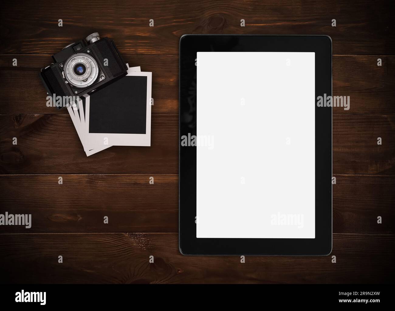Fotocamera retrò con scheda fotografica vuota e tablet su tavolo di legno Foto Stock
