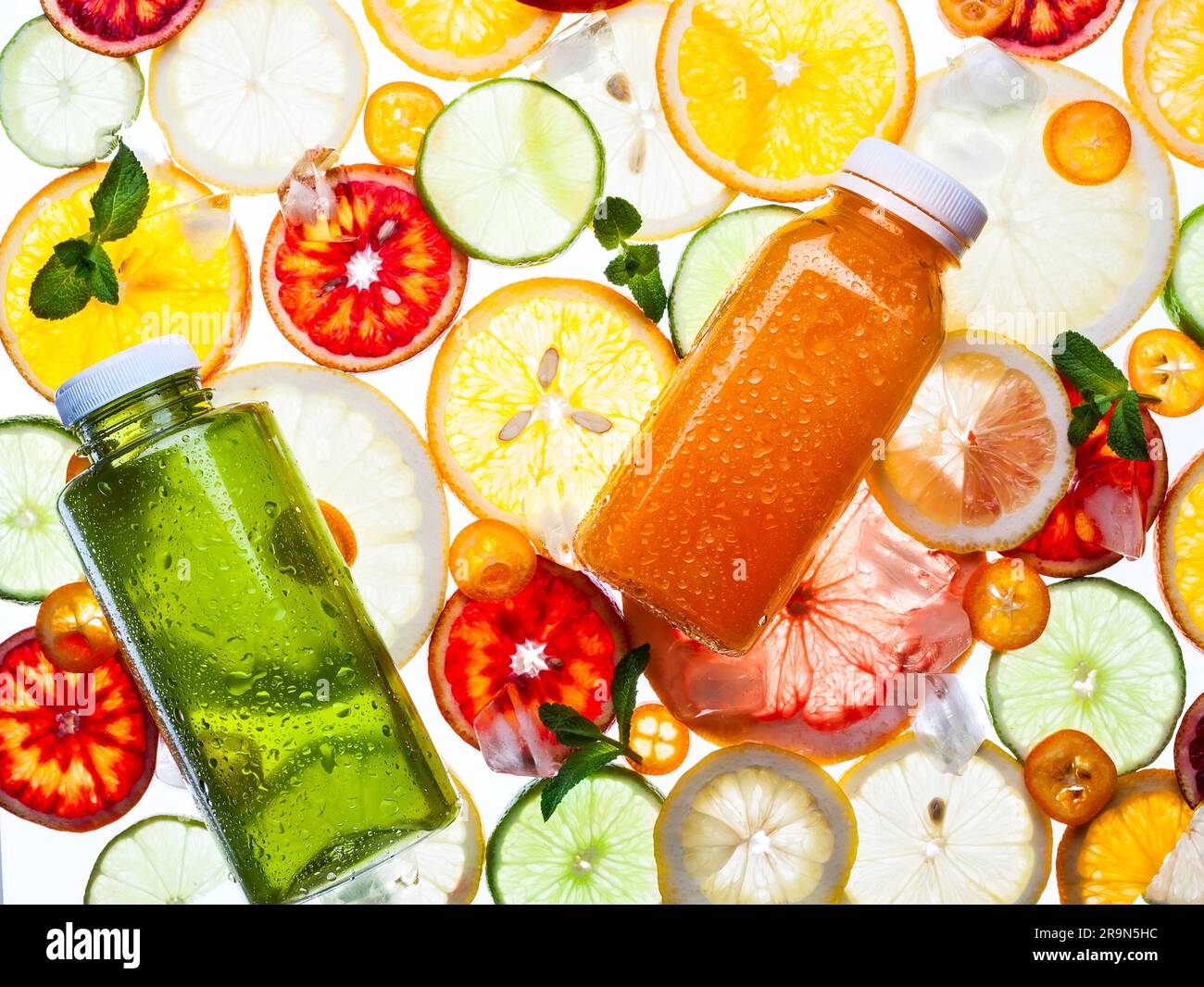 Bottiglie di succo fresco sullo sfondo degli agrumi. Ripetizione trasparente. Foto Stock