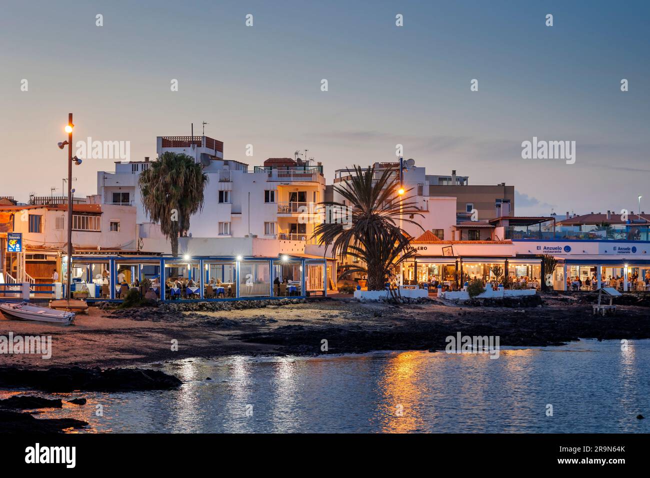 Ristoranti e bar sul lungomare al crepuscolo Town Beach Corralejo Fuerteventura Foto Stock