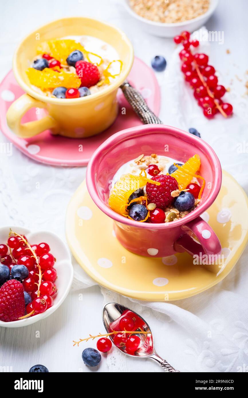 Colazione salutare con muesli, yogurt e frutti di bosco freschi in tazza Foto Stock