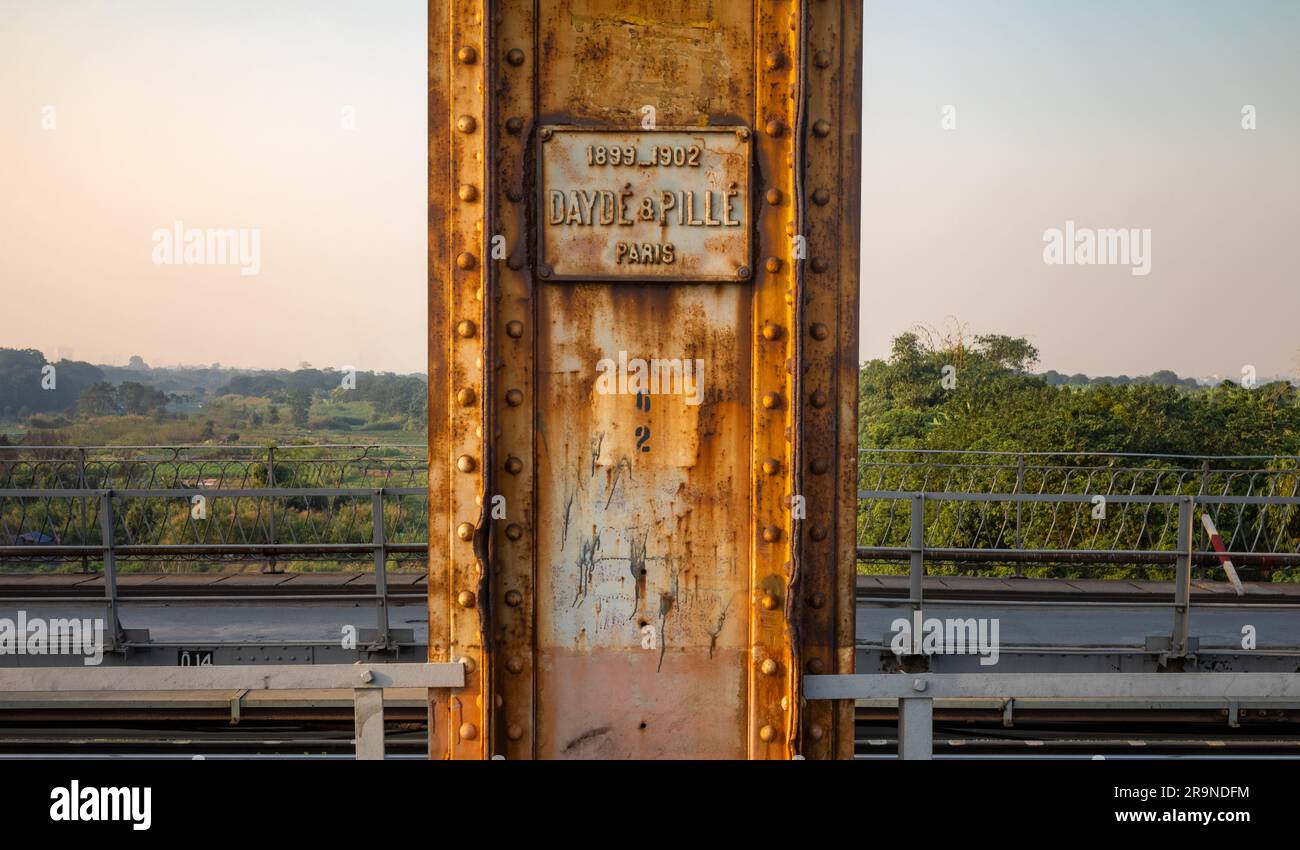 Un palo verticale in acciaio arrugginito sul Long Bien Bridge ad Hanoi, in Vietnam, che mostra una targa con i nomi degli architetti Dayde & Pille a Parigi, in Francia e le date Foto Stock