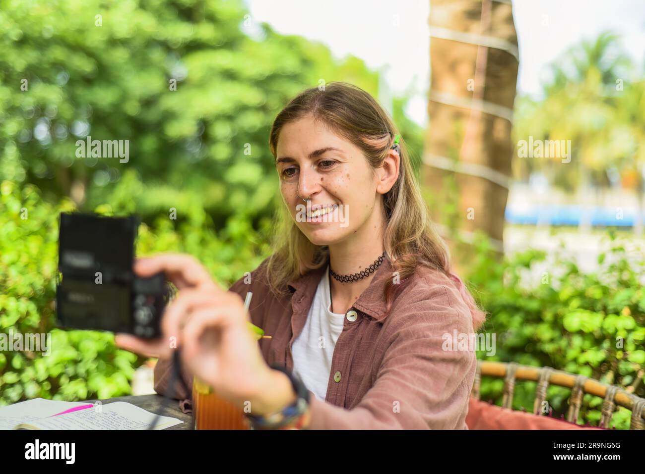 Donna carina che scatta un selfie fotografico con una fotocamera digitale Foto Stock